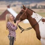 Attractive young lady and horse looking at each other